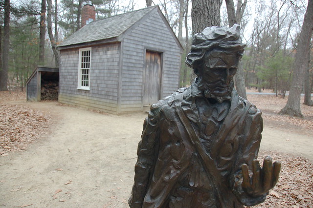 Statue of Thoreau in front of a replica of the cabin he lived in while he was writing 