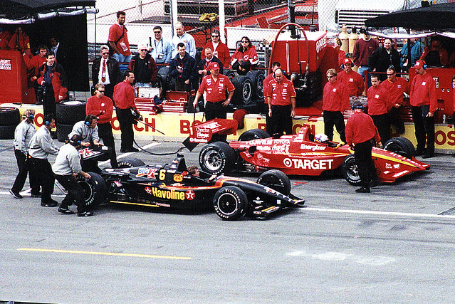 #6 Michael Andretti's car is pushed past #1 Juan Montoya