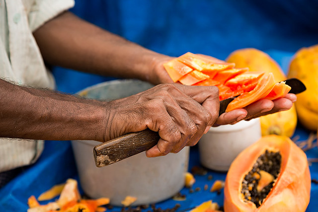 Man cutting papayas in the streets of Kolkata, India.