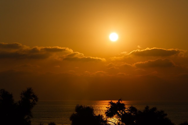 Sun setting through clouds over the Mediterranean Sea