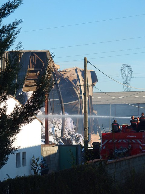 View of the fire brigade at work, cooling the wrecks and the stacks of paper