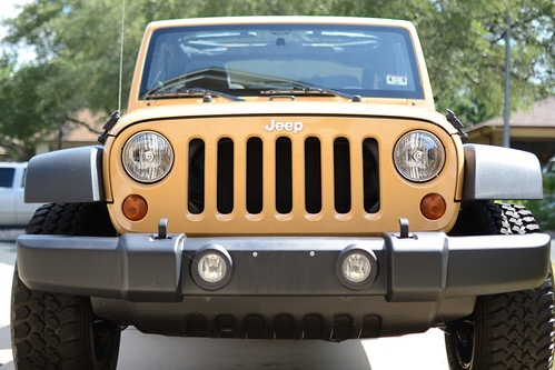 Close up of front of yellowish jeep