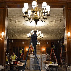 Workers clean and organize the first-floor Mary Duke Biddle Room, which will service as an open-to-the-public exhibit space in Rubenstein Library. Over three days, about 30 portraits of prominent figures of Duke history, from university architect Julian A