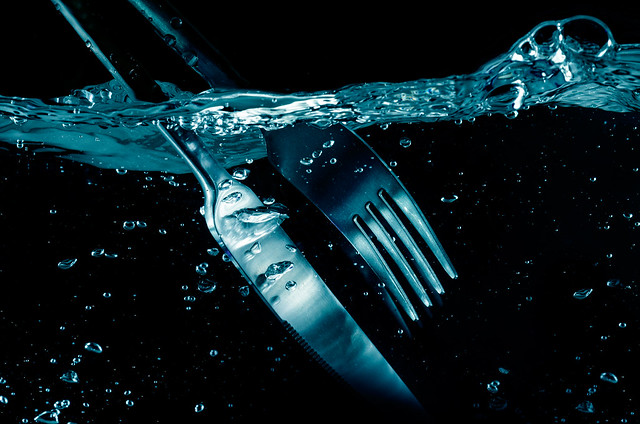 splashing  Fork and  Knife in water. on black