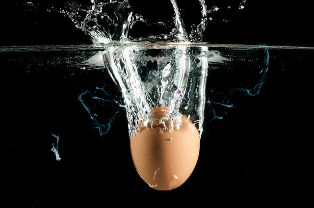 egg splashing in water. over black