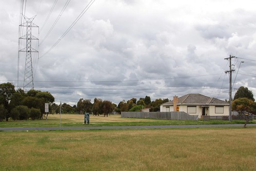 A lone house sits beneath the transmission lines