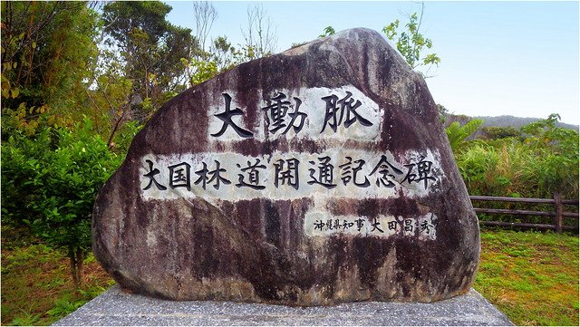 MONUMENT TO THE COMPLETION OF THE SOUTHERN PORTION OF OKINAWA'S 52-KILOMETER-LONG MOUNTAIN ROAD THROUGH THE NORTHERN FORESTS