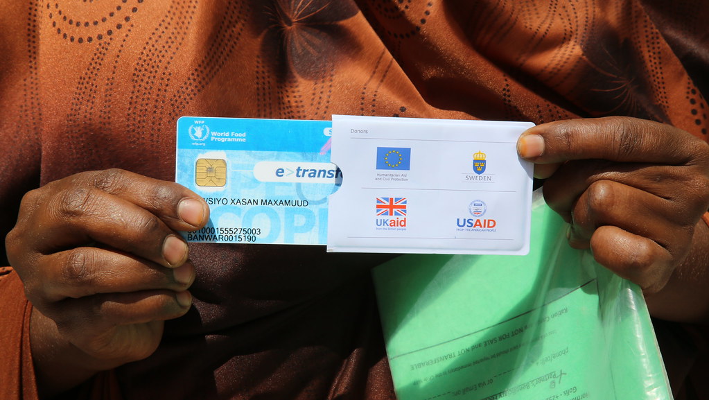 A woman holds a World Food Programme e-card in Somalia, Ma… - Flickr