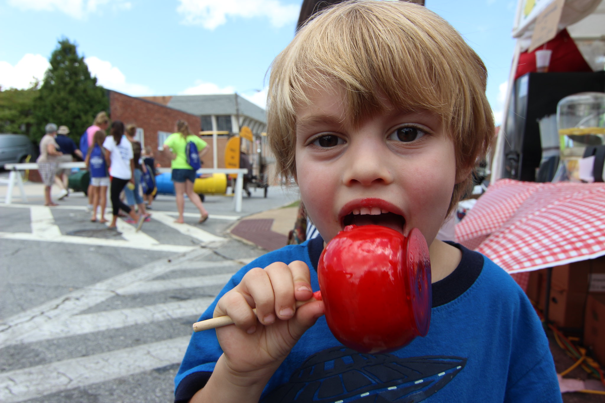 Kid having fun with a caramel apple at one of the apple festivals in the Carolinas