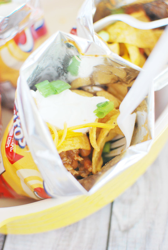 Walking Tacos - Fritos, taco meat, beans, cheese, and sour cream layered in the chip bag for an easy dinner idea! Kids love these!