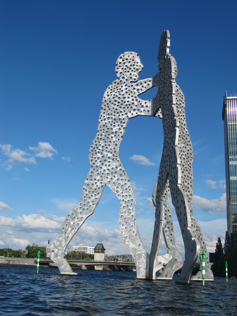 The Molecule Men statue is three large male figures, dotted with holes, about to embrace 