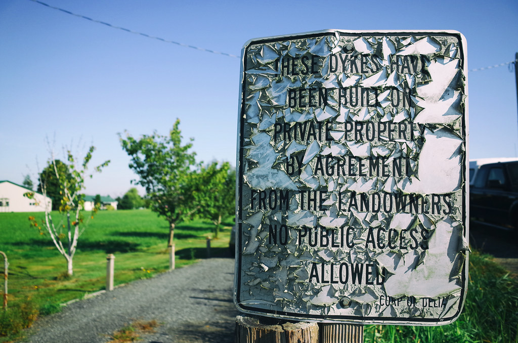 Blue sky, green farm, weathered sign