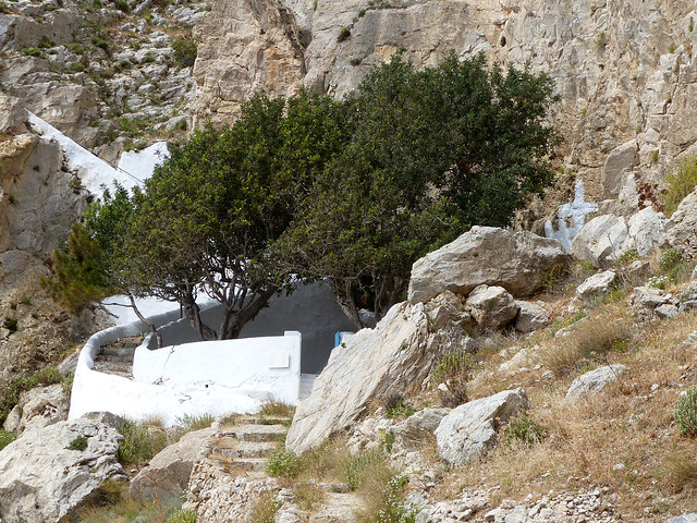 La placette de la chapelle Zoodochos Pigi (Source de vie), sur le flanc est du mont Profitis Ilias, à l'ombre de deux caroubiers