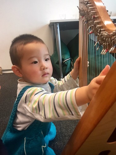 Child tries out the harp, Upper Riccarton Library