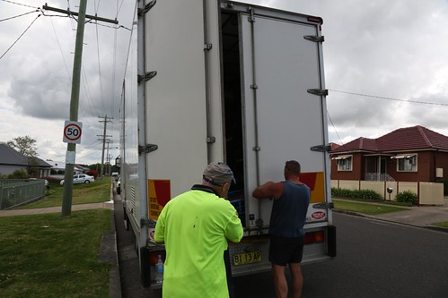 Removal firm workers securing truck door photo. | by sunset_removals