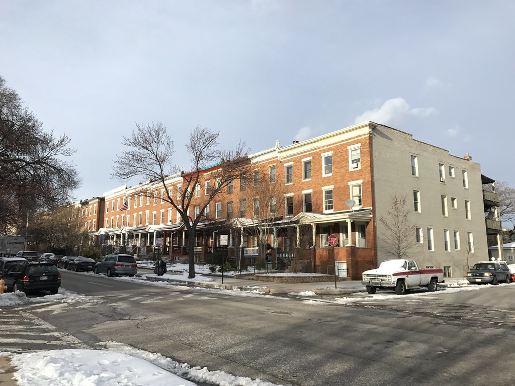 A block of brick rowhouses with porches.