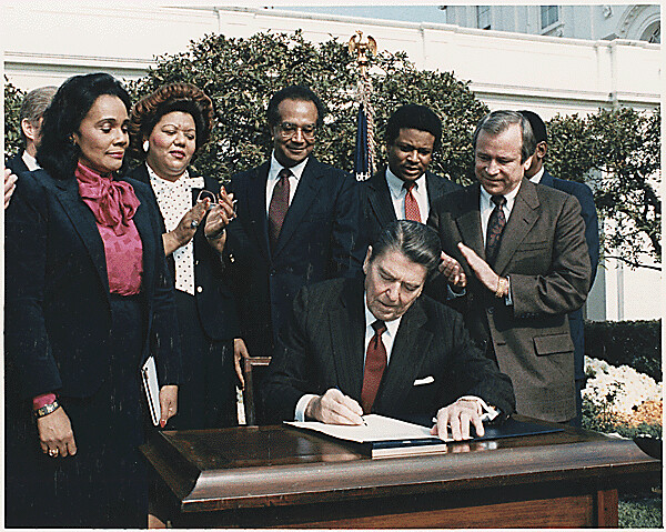 Photograph of President Reagan and the Signing Ceremony for Martin Luther King Holiday Legislation, 11/02/1983 - 11/02/1983