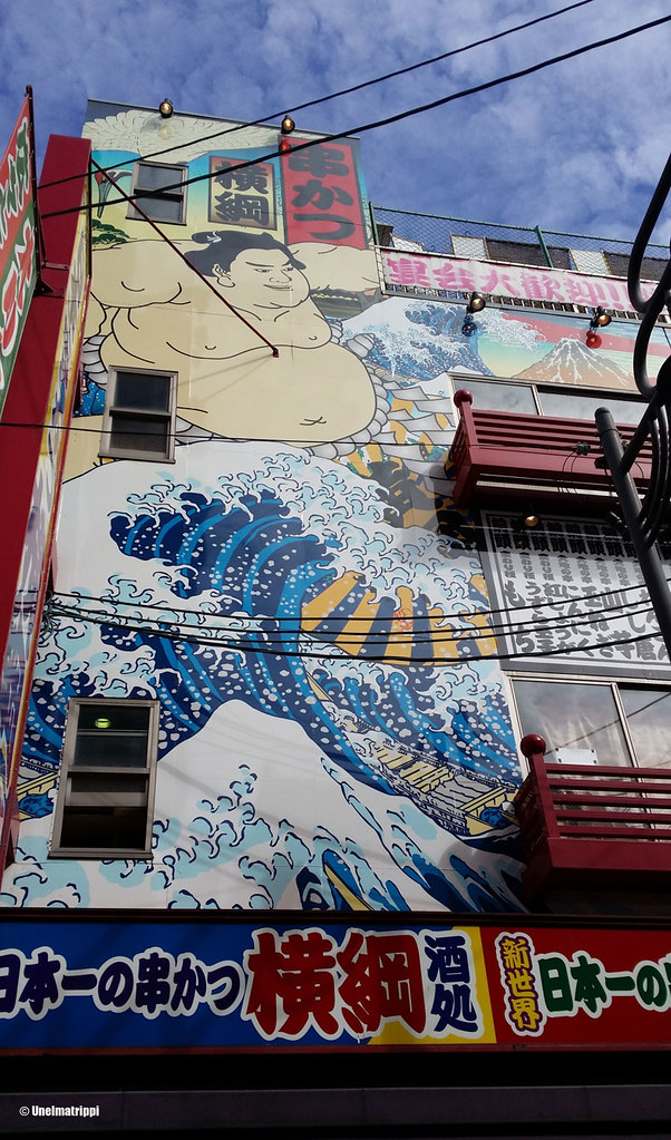 Talon seinään maalattu aalto ja sumopainija Shinsekaissa