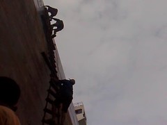 Workers climbing ladder to ship's deck