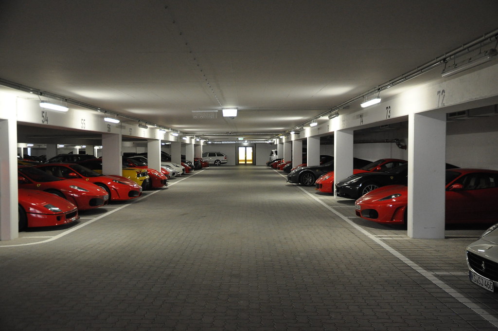 Аренда машино. Большой гараж. Гараж Ferrari. Феррари в гараже. Парковка спорткаров.