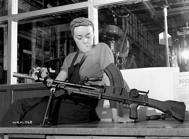 Veronica Foster, known as “The Bren Gun Girl,” poses with a finished Bren gun at the John Inglis & Co. plant / Veronica Foster, surnommée « la fille au fusil-mitrailleur » pose avec un fusil-mitrailleur Bren assemblé à l’usine John Inglis & Co.