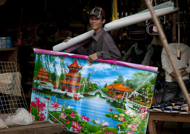 Chinese poster seller on a Laos market