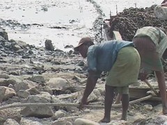 Barefoot workers hauling metal ashore