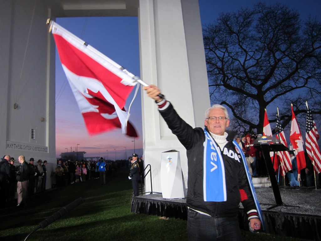 Canada work permit freeze shown through a Canadian flag outside a federal building