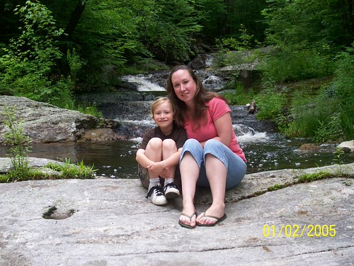 jen and hayden on a rock in the middle of a stream | by abnrml_5683