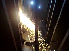 Sparks from blowtorch rain down into the ship