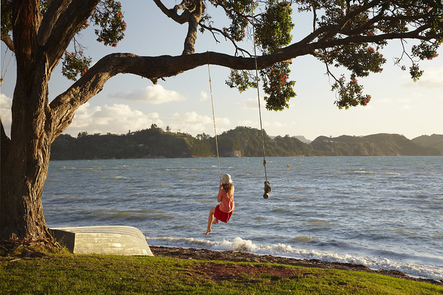 Young Girl on Rope Swing under Pohutukawa Tree, Oamaru Bay, Coromandel, North Island, New Zealand