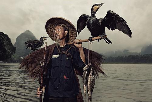 A Chinese fisherman with his two cormorants by Glenn Meling