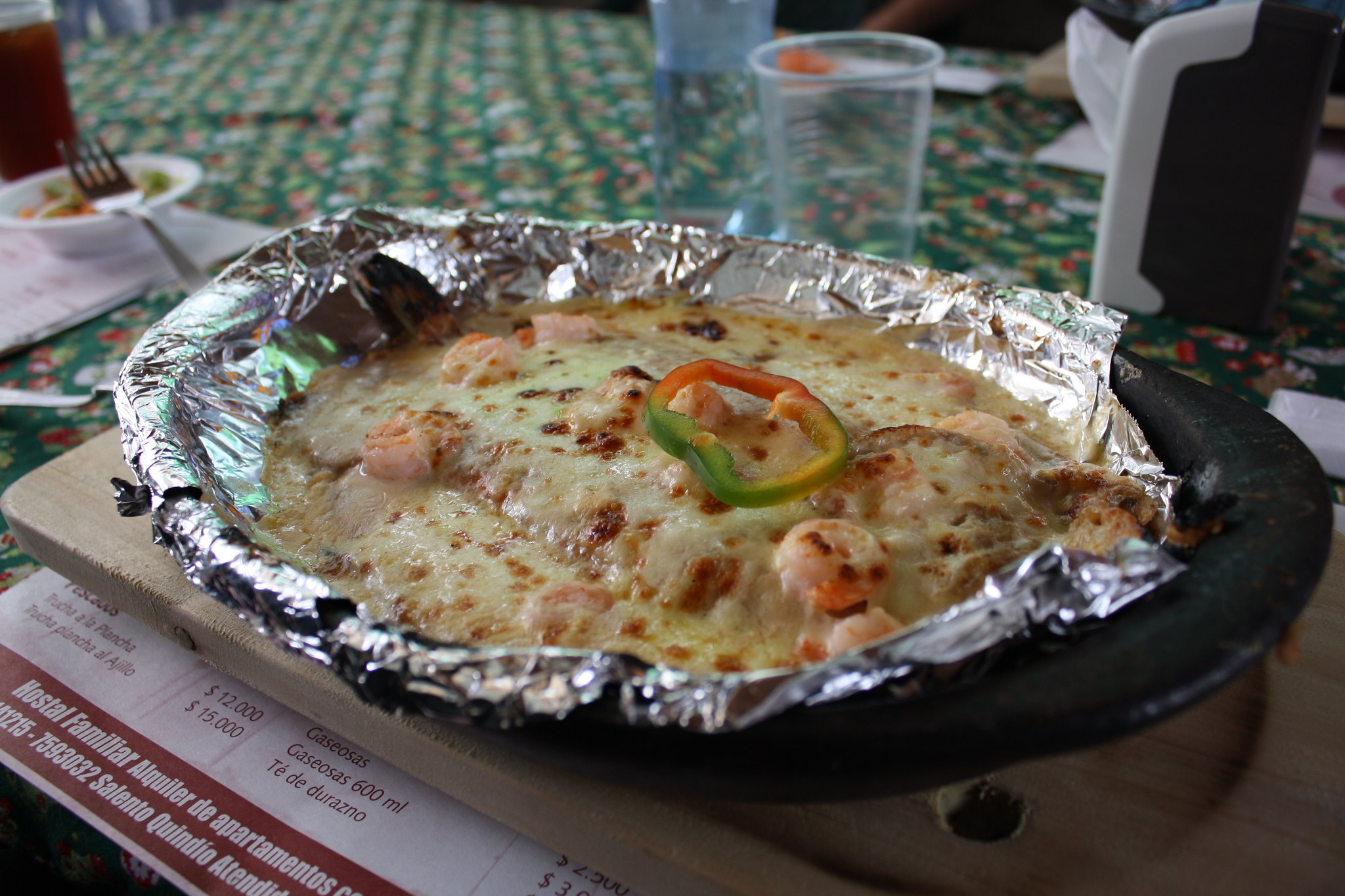 Cacerola que contiene un pescado con una cubierta de queso