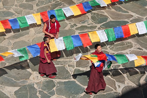 Monks unwinding prayer flags