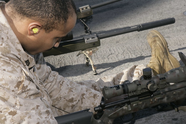 Marine adjusts a sniper rifle
