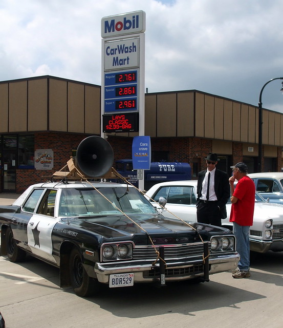 Man Dressed As A Blues Brother Stands Next To The Blues Brothers Dodge Monaco.
