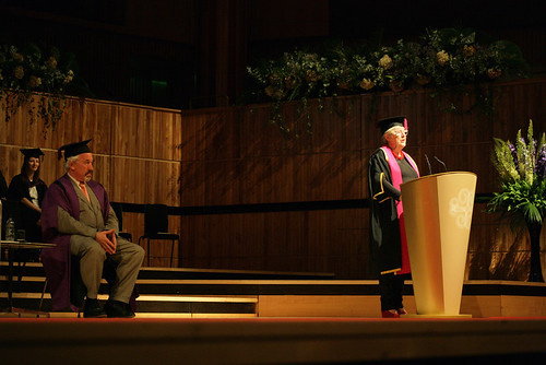 Professor Jane Rapley, Head of College CSM, addressing the assembly, with Simon Callow, Honorary Fellow, in the background