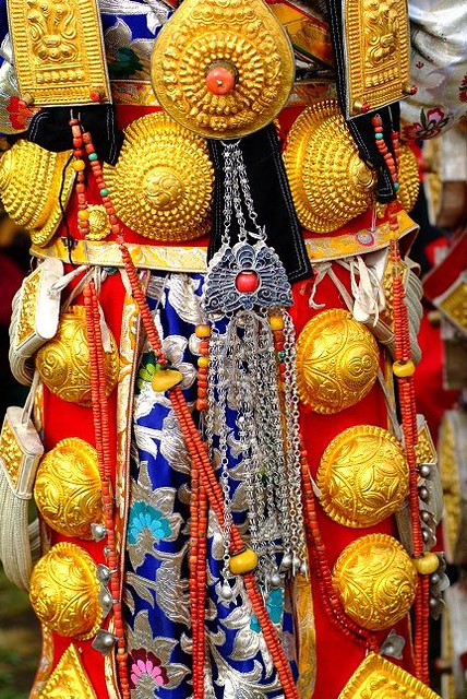 Ornate, massive, pure gold ornaments worn by bejewelled girl at Lithang Horse Festival