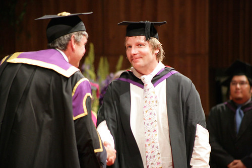 Rector Nigel Carrington congratulating a graduating student