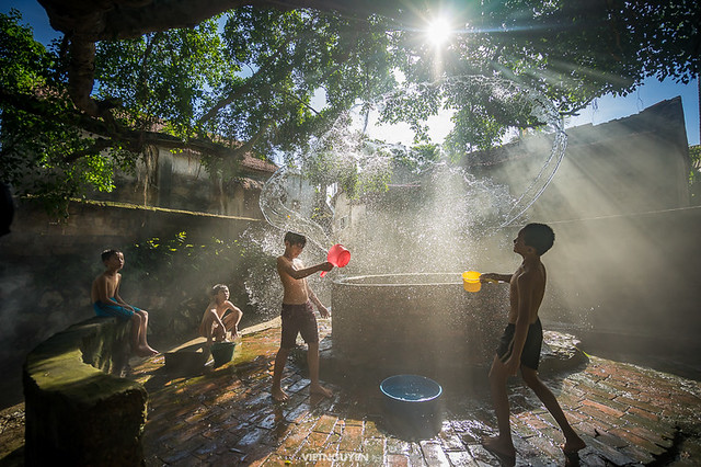 Countryside children play near the ancient shaft in a village in suburb of Hanoi, Vietnam.
