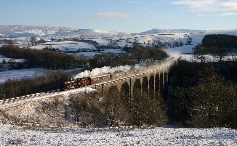 Jubilee No.5690 'Leander' sweeps round the curve over Smardale Viaduct on a crisp Winters day. It looks like there is a trail of steam along the coaches, but it is actually the snow from the lineside being disturbed by the passing train.