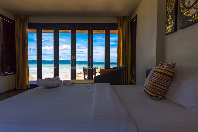 Bedroom (Interior) - Sea View and Blue Sky through Glass Door Frame.