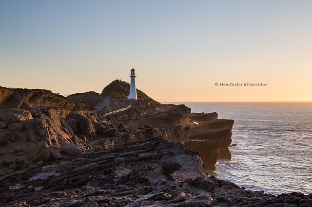 rocky cliff and Castlepoint lighthouse in sunrise light