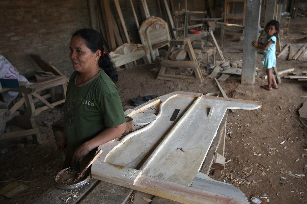 Female worker begins on wood filling a new piece. Jepara, Central Java, Indonesia.