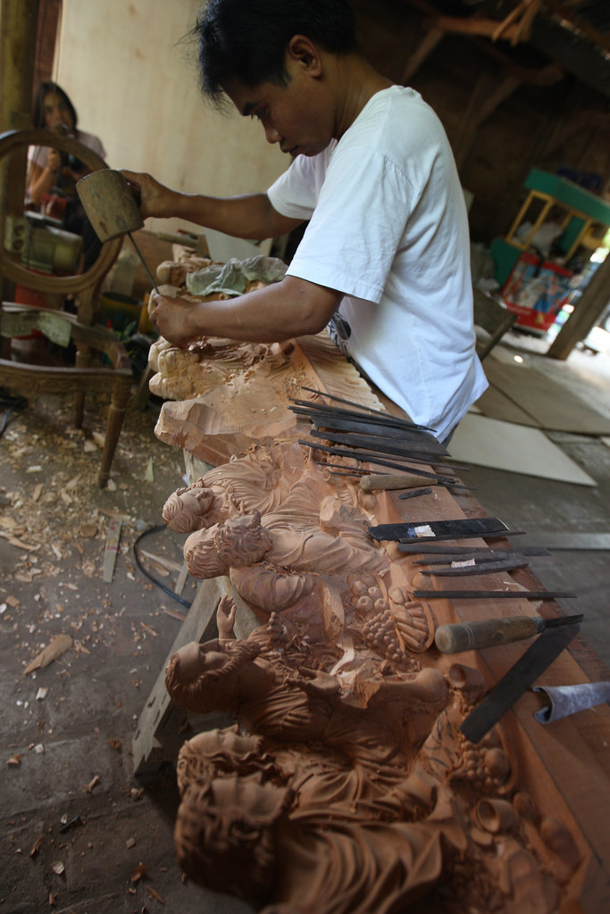 Male worker re-creates, in wood, Leonardo da Vinci's The Last Supper. Jepara, Central Java, Indonesia.