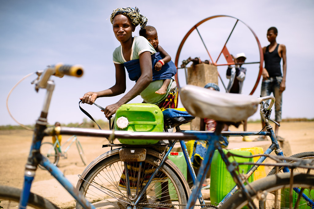Barry Aliman, 24 years old, bicycles with her baby to fetch water for her family, Sorobouly village near Boromo, Burkina...
