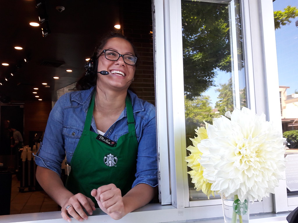 The happy smile of Malia, green apron, a Starbucks employee on duty, flowers, drive up window, Dash Point Road, Federal Way, Washington, USA