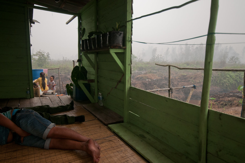 A man resting in his home. Thick smoke from peat fires disrupt the daily activities of local people. Outside Palangka...
