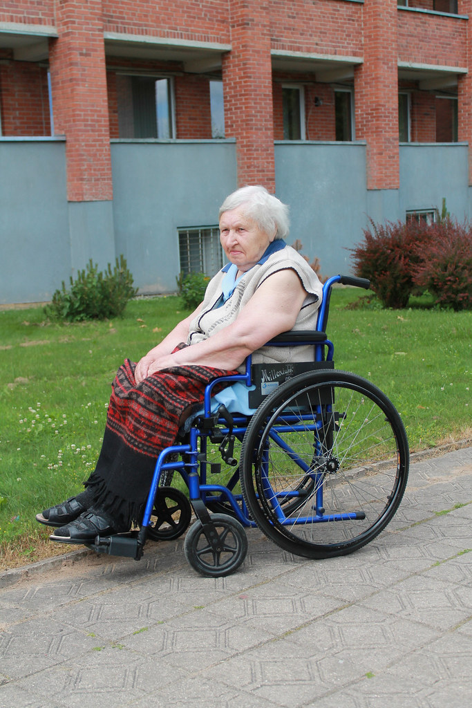 Senior older woman in wheelchair outdoors