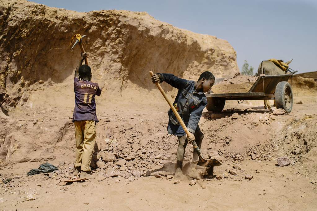 District 30 of Ouagadougou, one of the capital’s poorest neighborhoods, children dig and move dirt for making bricks and plastering...